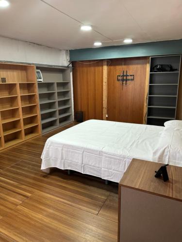 a bedroom with a large bed and wooden cabinets at Habitaciones Espacio in Corbera de Alcira