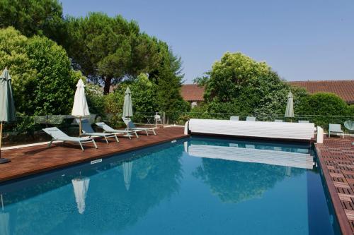a swimming pool with two chairs and umbrellas at Résidence de Diane - Toulouse in Toulouse
