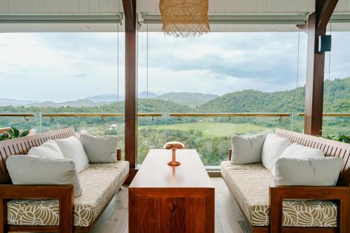 a living room with two couches and a large window at The RIYAZ Lavanya Langkawi in Pantai Cenang