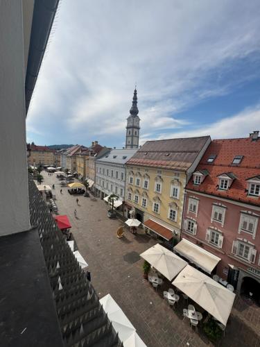 a city street with a clock tower in the background at cozy big old town apartment in Klagenfurt