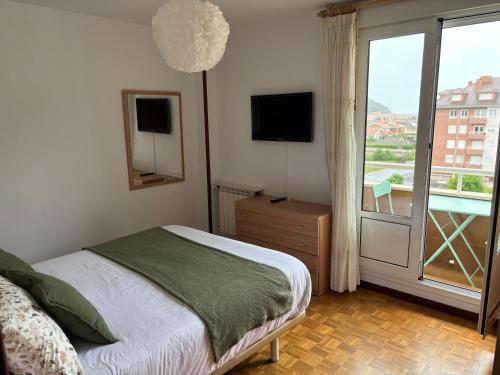 a bedroom with a bed and a large window at La Piragua in Ribadesella