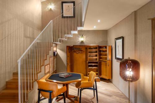 a room with a table and chairs and a staircase at The James Suite Hotel Firenze 1564 - Small Luxury Hotels of the World in Florence
