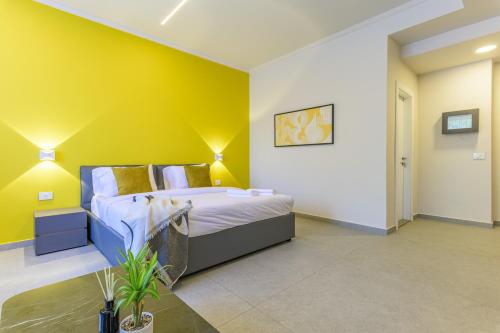 a bedroom with a bed and a yellow wall at CityZen - Boutique Studios in Achrafieh in Beirut