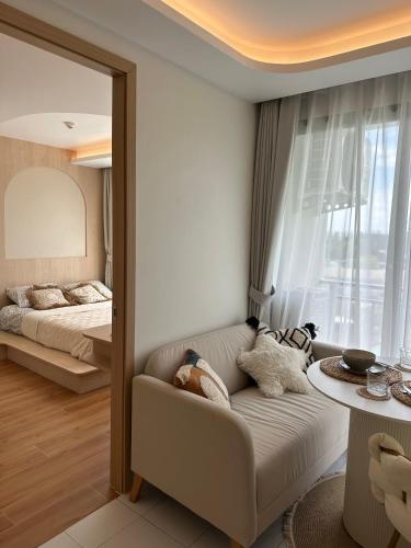 a living room with a couch and a bed at Fantasea Condo Kamala in Kamala Beach