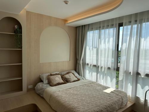 a bedroom with a bed and a large window at Fantasea Condo Kamala in Kamala Beach