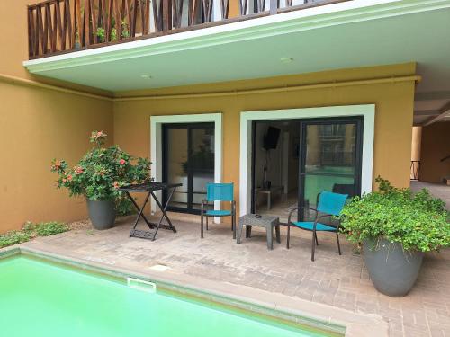 a patio with chairs and a table next to a pool at Forest View Apartments in Kololi