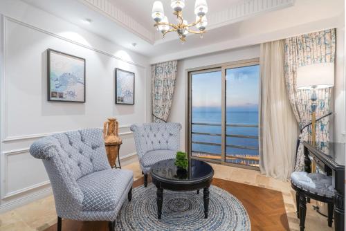 a living room with two chairs and a table at Liman Hotel & Casino by Merit in Kérynia