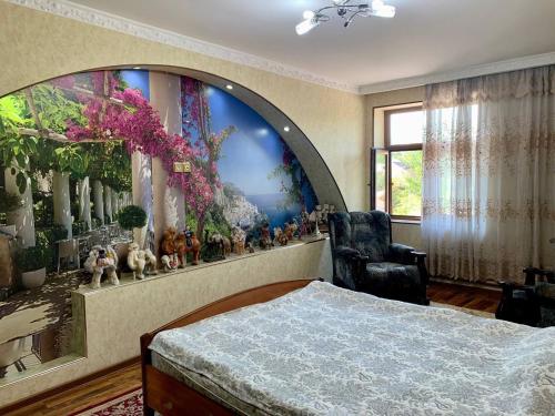 a bedroom with a large painting on the wall at Muassanit House - Onix in Stantsiya Kyzyl-Tukumachi