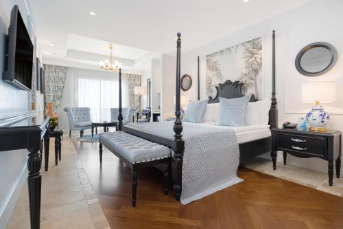 a bedroom with a four poster bed and a table at Liman Hotel & Casino by Merit in Kérynia