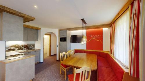a kitchen and dining room with a red couch and a table at Hotel - Restaurant - Sonnblick in Heiligenblut