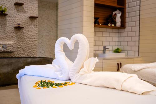 two towels shaped like swans sitting on a table at The RIYAZ Lavanya Langkawi in Pantai Cenang