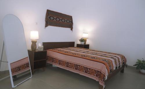 a bedroom with a bed with two lamps and a mirror at Kalyana Guest House in Bandung