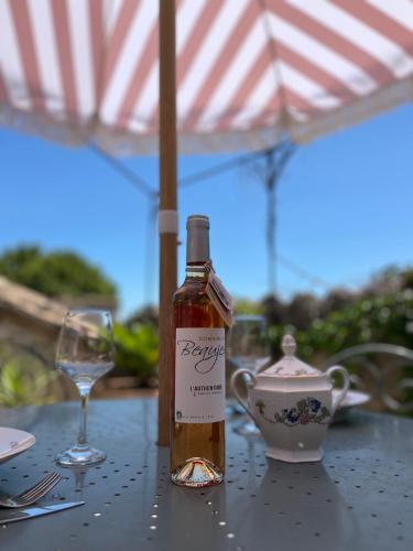 - une bouteille de vin assise sur une table avec un verre dans l'établissement La confidentielle Centre ville Arles Terrasse, à Arles