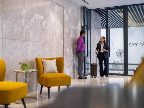 a man and a woman with a suitcase in a room at W Residence Living in Dhaka
