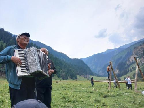 a woman playing an accordion in a field at Aidar in Arkit