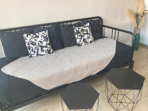 - un lit noir avec des oreillers dans l'établissement La Venise du Languedoc Sète,Terrasse,mer,cosy, à Sète