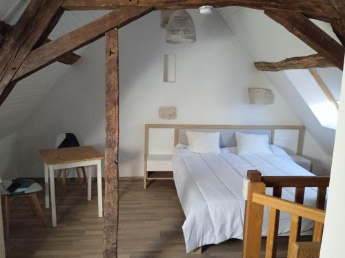 a bedroom with a white bed in a attic at Duplex indépendant dans Longère in La Croix-en-Touraine