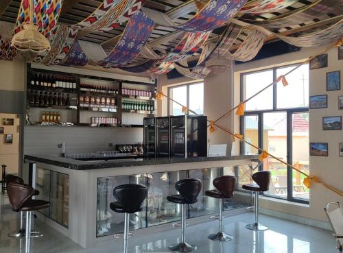a bar with stools at a counter in a room at Fengchui Banxia Manor Wild Luxury Camp in Taxkorgan