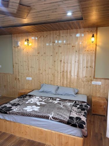 a bedroom with a bed in a wooden wall at TY Homestay Sissu By Soma Stays in Sissu