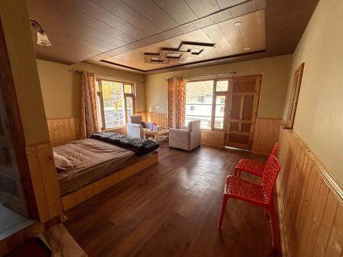 a bedroom with a bed and a chair in a room at TY Homestay Sissu By Soma Stays in Sissu