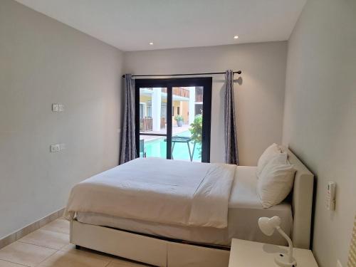 a bedroom with a bed and a window at Forest View Apartments in Kololi