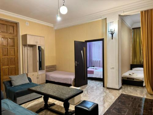 トビリシにあるNana's Apartment with gardenのベッド2台とテーブルが備わる部屋1室を利用します。