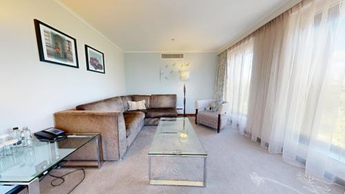 a living room with a couch and a table at Hilton London Heathrow Airport Terminal 5 in Hillingdon