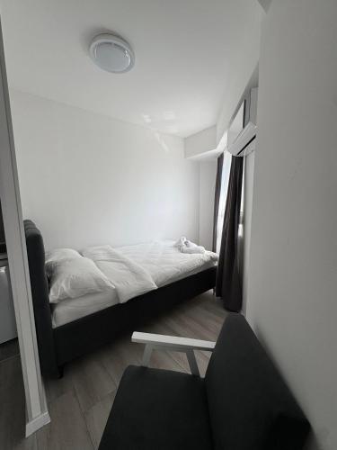 a small room with a bed and a chair at Apartmani PROM-AR in Travnik