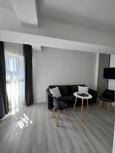 a living room with a black couch and a table at Apartmani PROM-AR in Travnik