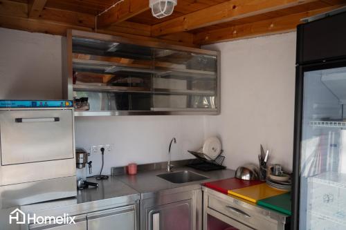 a kitchen with a sink and a refrigerator at Avra Seafront Villa in Diliso