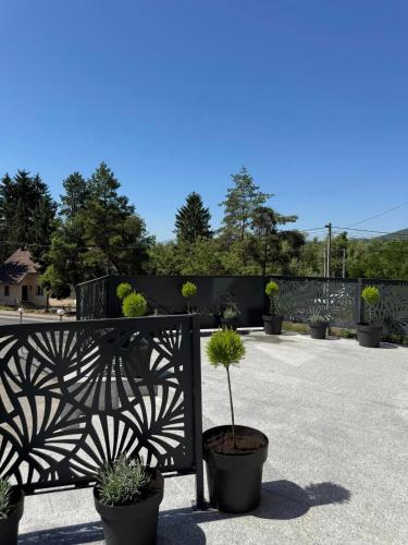 a black fence with potted plants on it at Apartmani PROM-AR in Travnik
