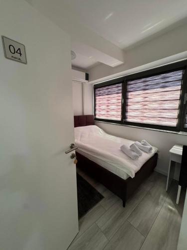 a small bedroom with a bed and a window at Apartmani PROM-AR in Travnik