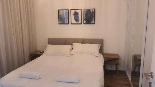 a bedroom with a white bed with two pillows at Beyond 42 Eilat in Eilat
