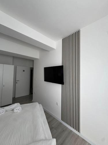 a bedroom with a bed and a television on a wall at Apartmani PROM-AR in Travnik