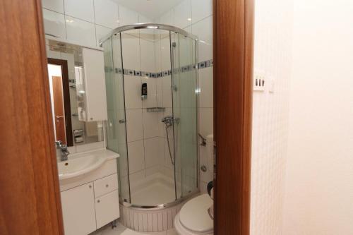a bathroom with a shower and a toilet and a sink at Hotel Pansion Villa Antonio in Orebić
