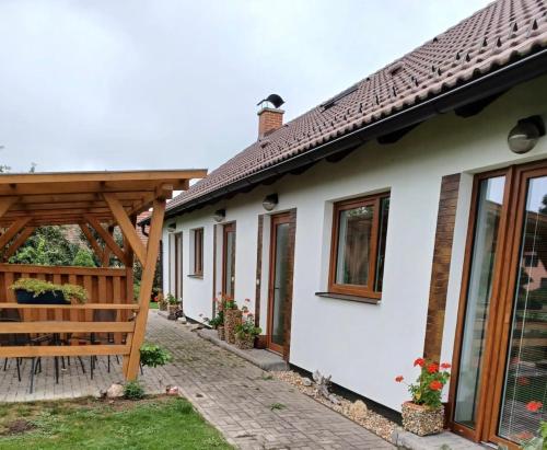 a white house with a wooden pergola at Apartmány Kojčice 