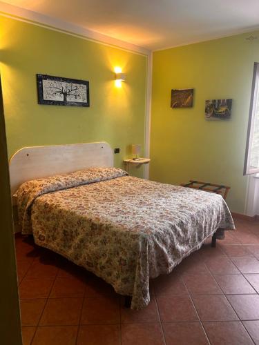 a bedroom with a bed in a room with green walls at Agriturismo Tre Tigli in Asti