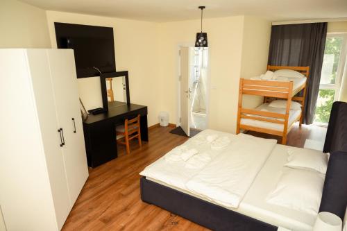 a bedroom with a bed and a desk and a mirror at Hotel & Restaurant Frida in Gjakove