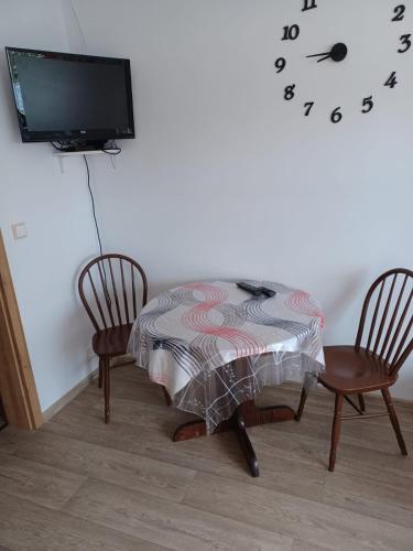 a room with a table and two chairs and a tv at Apartmány Kojčice 