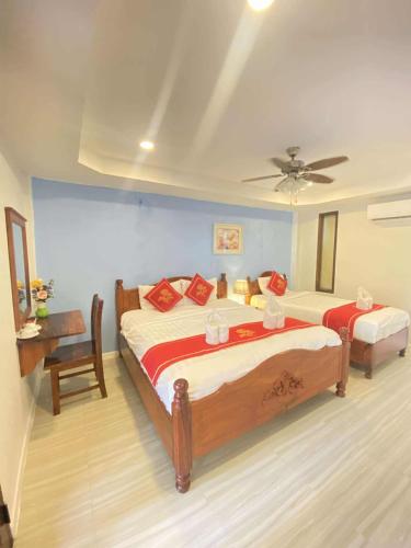 a bedroom with two beds and a ceiling fan at Luang Prabang Golden Lotus Villa River View in Luang Prabang