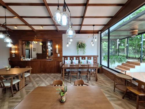 a restaurant with wooden tables and chairs and windows at Le-Mao Chiang Dao in Chiang Dao