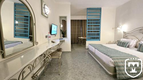 a hotel room with a bed and a bathroom at Hotel La Residence Hammamet in Hammamet