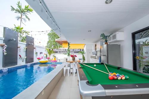 a pool table next to a swimming pool with a billiard table at Hunter Hide Pool Villa in Jomtien Beach