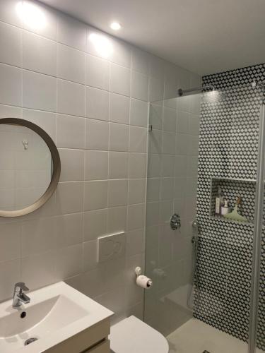 a white bathroom with a shower and a sink at Avô Moreira Beach House in Póvoa de Varzim