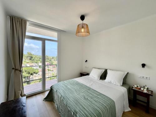 a bedroom with a bed and a large window at Cala Morisca full AC Sea View Home in Tossa de Mar