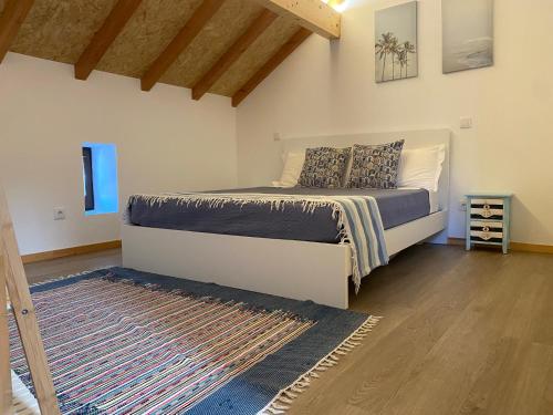a bedroom with a bed and a rug at Avô Moreira Beach House in Póvoa de Varzim