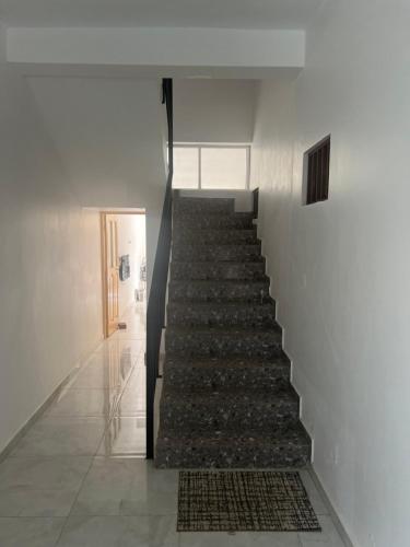 a staircase in a white building with a rug at Casa Ida 2 Tarrafal, Cape verde in Tarrafal