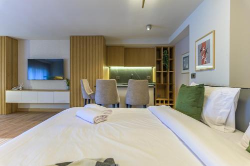a bedroom with a large bed and a kitchen at CityZen - Boutique Studios in Achrafieh in Beirut