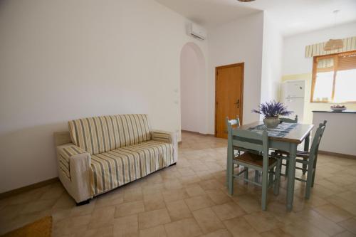 a living room with a couch and a table and a chair at filìa ϕιλία in Serranova