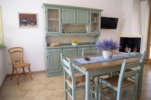 a kitchen with green cabinets and a table and chairs at filìa ϕιλία in Serranova
